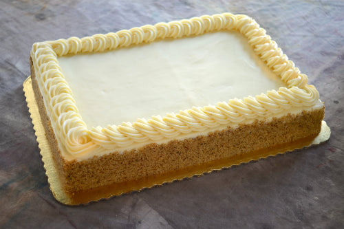 Large 9x13 sheet cake with white frosting, piped border, nut-coated sides, on a gold cardboard base.